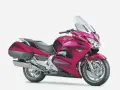 Różowy motocykl Honda ST 1300, gotowy na długie trasy, choć czasem zdarzają się mu drobne awarie.