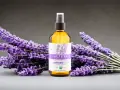 Butelka z organiczną wodą lawendową Alteya Organics otoczona bukietami fioletowej lawendy.