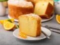 Wilgotna babka cytrynowa, posypana cukrem pudrem, z pomarańczowymi akcentami. Idealna na szybki deser.