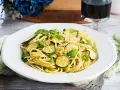 Un piatto di pasta e zucchine alla siciliana, guarnito con menta fresca e parmigiano.