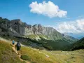 Deux randonneurs explorent un sentier escarpé au Pays Basque, sous un ciel bleu et des falaises imposantes.