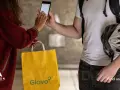 Kobieta płaci za dostawę Glovo telefonem. Różne glovo metody płatności są dostępne.