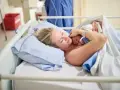 Szczęśliwa mama tuli noworodka. To początek jej urlop macierzyński, pełen miłości i czułości.