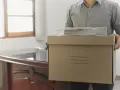 Hombre con caja de cartón y papeles, listo para irse. ¿Los 15 días de preaviso son naturales o laborales?