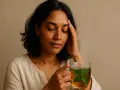 Donna con mal di testa che beve una tisana alla menta, uno dei rimedi naturali per il mal di testa.