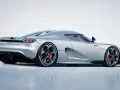 Srebrny Koenigsegg CC850 z czerwonymi zaciskami hamulcowymi i charakterystycznymi felgami.