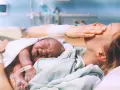 Nowy człowiek na świecie! Po długim porodzie, wyczerpana mama tuli swoje maleństwo.