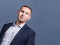 Mężczyzna w garniturze i białej koszuli, patrzący w górę.