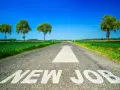 Strada asfaltata con freccia bianca e scritta "NEW JOB". Un percorso verso un futuro luminoso, ideale per chi sta pensando di cambiare lavoro a 30 anni.