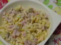 Pyszna sałatka z makaronem, szynką, ogórkiem i serem, polana kremowym sosem.