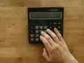 Main tenant utilise une calculatrice pour déterminer quel compte bancaire à l'étranger doit-on déclarer.