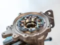 Metalowa obudowa turbosprężarki z widocznym mechanizmem kierownic spalin, kluczowym dla działania biturbo.