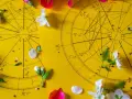 Dwa koła horoskopowe na żółtym tle, ozdobione płatkami kwiatów. 21 czerwiec znak zodiaku.