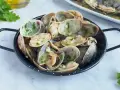 Almejas en salsa verde, un plato delicioso con mariscos frescos y perejil picado, listo para disfrutar.