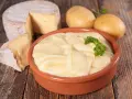 Aligot receta: puré cremoso de patatas y queso, con patatas y queso de cabra al lado.