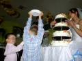 Jak zorganizować opiekę nad dziećmi podczas wesela? Rodzice z dziećmi przy wielopiętrowym torcie weselnym.