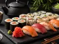 Piękna taca z sushi: rolki z łososiem, tuńczykiem, krewetką, nigiri i dodatkami. Obok czajniczek i miseczka z sosem. Idealna zaprawa do sushi.