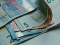 Euro banknoty, w tym 5, 20 i 50 euro, leżące na stole. Zastanawiasz się, jak rozliczyć się z ubezpieczenia w Holandii?