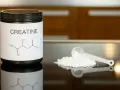 Dose Creatin Pulver mit Messlöffel. Die Frage "wie viel Creatin am Tag" wird hier visuell thematisiert.