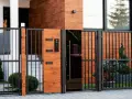 Nowoczesna brama z drewnianymi panelami i czarnym szkłem. Zastanawiasz się, dlaczego po 20 września 2026 nie dostaniesz odbioru domu przez złą bramę?
