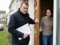Mężczyzna z teczką stoi przy drzwiach, a kobieta otwiera je z niepokojem. Czy to początek historii o tym, jak pozbyć się windykatora terenowego?