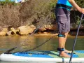 Person befestigt sup leash an Hüfte und Bein für sicheren Stand auf dem Board.