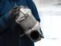 Osoba w rękawiczkach trzyma filtr cząstek stałych DPF.