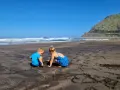 Dzieci budują zamki z piasku na czarnej plaży. Teneryfa atrakcje dla dzieci to raj dla małych odkrywców.