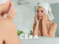 Kobieta z ręcznikiem na głowie aplikuje krem pod oczy, by pozbyć się ziemistej cery.