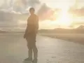 Leon S. Kennedy, protagonista de Resident Evil 2 Remake, se alza en un camino desolado al amanecer, listo para enfrentar lo que venga.