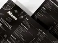 Czarne, eleganckie menu restauracji z rysunkami pizzy i sztućców. Zawiera sekcje: Zupy, Dania Główne, Makaron, Pizza.