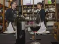 Winiarnia, butelka i kieliszek czerwonego wina na stole. Zastanawiasz się, czy można przewozić alkohol w bagażu rejestrowanym?