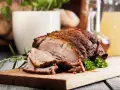 Rozpływająca się karkówka z piekarnika, soczysta i aromatyczna, podana z gałązką rozmarynu na desce.