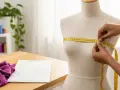 Manos midiendo un maniquí con cinta métrica amarilla, demostrando cómo tomar las medidas del cuerpo para confección.