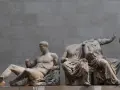 Statues grecques antiques, dont un homme musclé assis et des figures féminines drapées, témoignant de l'art hellénistique.