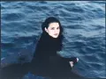 Kobieta w czarnym swetrze siedzi na burcie statku, wpatrując się w fale. Zaprasza: "come away with me".