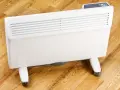 Biały, nowoczesny grzejnik elektryczny na kółkach, idealny do ogrzewania domu. Sprawdź nasz energooszczędne grzejniki elektryczne ranking!