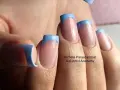 Unghie french con disegni azzurri e base rosa. Un tocco di colore per un look fresco e moderno.