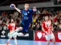 Piłkarz ręczny w skoku, z piłką w dłoni, podczas jednego z emocjonujących gwardia opole mecze.
