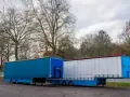 Dwa naczepy ciężarowe, jedna niebieska, druga biała, stoją obok siebie. Symbolizują one dynamiczną branżę TSL.