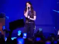 Lana Del Rey, w czarnej, prześwitującej bluzce i sportowych spodniach, śpiewa na scenie. Fani z telefonami tworzą tłum. To jej lana del rey opener.