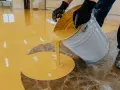 Wylewanie żółtej żywicy na podłogę. Sprawdź, jaka jest podłoga z żywicy cena za metr.