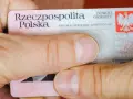Dłonie trzymają polski dowód osobisty. Widoczny jest numer dowodu osobistego.