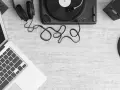Laptop z programem do produkcji muzyki, gramofon, słuchawki i głośniki. Tworzenie utworu muzycznego z samplera.