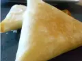 Deux samoussas dorés, un délice croustillant de brick chevre miel, prêts à être dégustés.