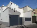 Fachada de casa con garaje, lista para como pintar una pared exterior en mal estado.