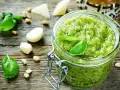 Frisches Pesto machen: Basilikum, Pinienkerne, Knoblauch und Parmesan auf rustikalem Holz.
