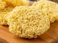 Suszone kluski do ramen na drewnianej desce. Idealne do szybkiego przygotowania pysznego dania.
