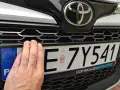 Dłoń zasłania część tablicy rejestracyjnej E 7Y541. Pod nią widoczny jest napis "STOP SMOG GO BEYOND ZERO".