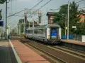 Pociąg Polregio z wygodnymi miejscami siedzącymi stoi na peronie.